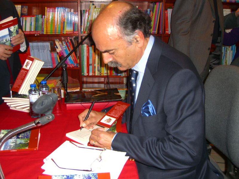 Autor autografando um exemplar do livro